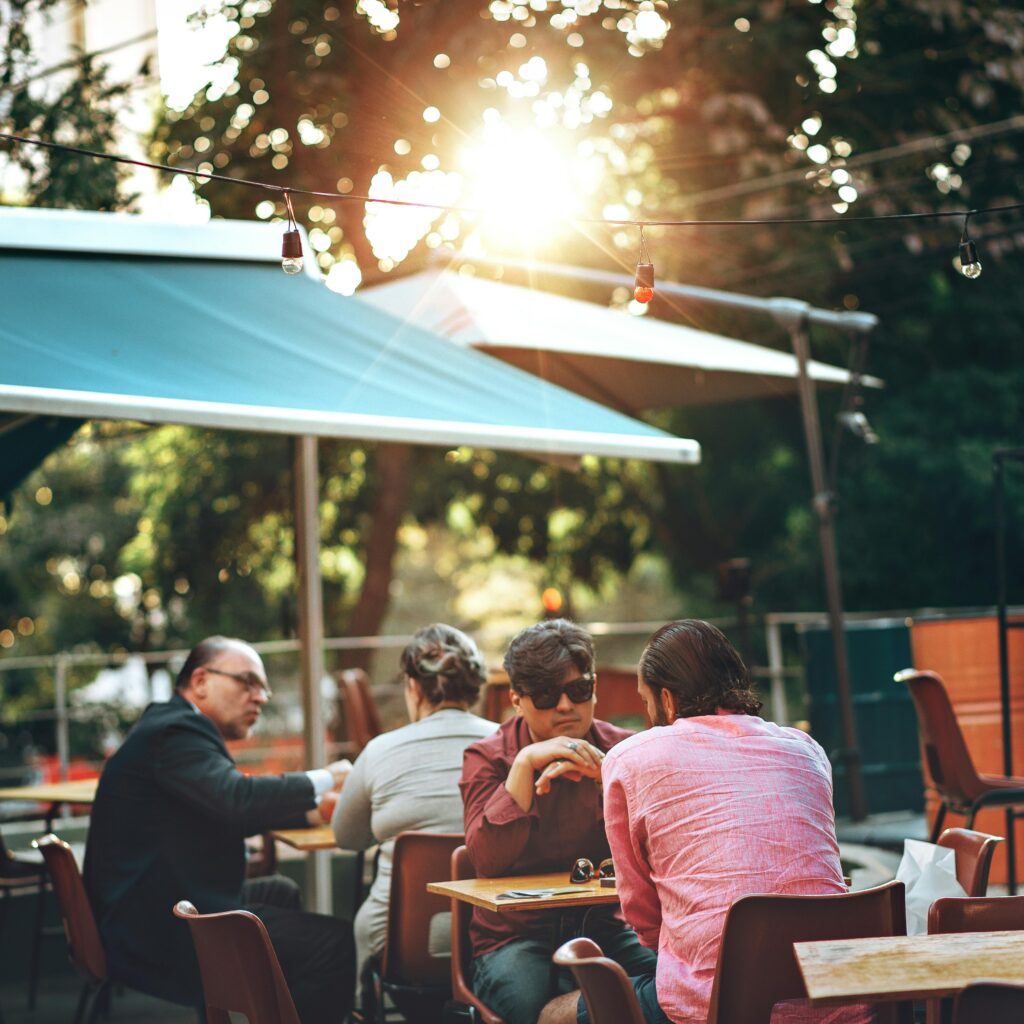 Casual outdoor dining scene at café in Belo Horizonte, Brazil with people enjoying leisure time.
